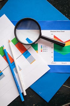 Image of financial charts and magnifying glass, ideal for business insights.